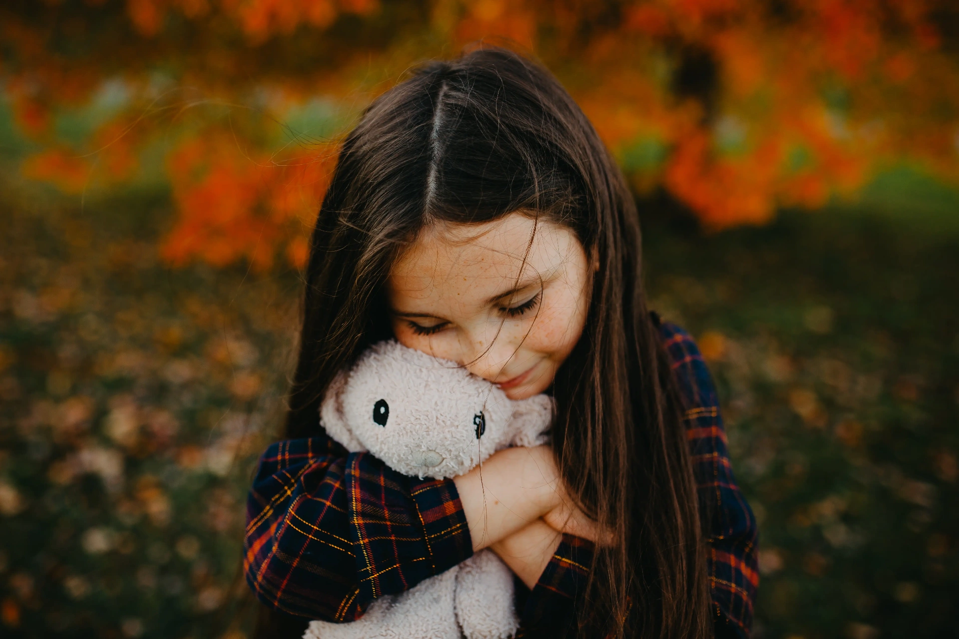 A young girl holding a plush bunny — imagery representing the Xander Community nonprofit